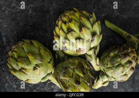 Artichaut frais sur fond noir. Gros plan Artichok brut Banque D'Images