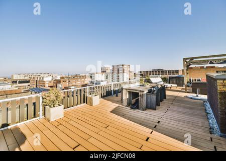 Terrasse avec table et chaises en bois sur le toit d'un immeuble et vue panoramique sur la ville Banque D'Images
