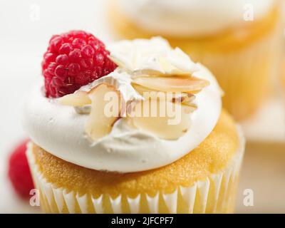 Prise de vue macro. Dessert d'été léger. Muffin à la crème aux protéines, framboises fraîches et amandes. Mets sucrés. Confiserie, traiteur, café, restaurant, hôtel. Banque D'Images