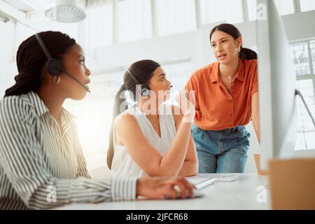 Jeune agent hispanique de télémarketing de centre d'appels formation de nouveaux assistants sur un ordinateur dans un bureau. Solution de dépannage pour les chefs d'équipe avec les stagiaires Banque D'Images