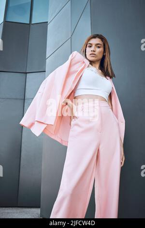 Portrait d'une jeune femme de course mixte, à la mode et confiante, qui a l'air élégante tout en posant et en faisant froid dans la ville. Femme hispanique à la mode Banque D'Images