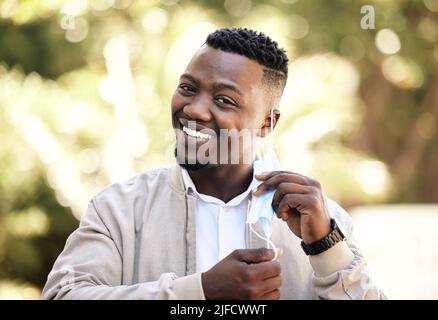 Portrait d'un jeune homme d'affaires debout dans la rue dans la ville souriant et regardant heureux un jour ensoleillé. Un homme afro-américain qui exprime son opinion Banque D'Images