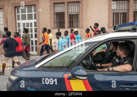 Melilla, Espagne. 01st juillet 2022. La police espagnole surveille les manifestants immigrants qui marchent dans les rues de Melilla pendant la manifestation. Aujourd'hui marque une semaine des événements où les combats de 23 personnes ont perdu la vie, des dizaines ont fini avec des blessures et beaucoup d'autres ont été détenus par la police marocaine, au poste frontière connu sous le nom de Chinatown dans le territoire marocain. Au cours des enquêtes, les deux États ont mis en place un bouclier qui reconnaît et apprécie la manière dont ils ont agi face à de tels événements, malgré les critiques de divers secteurs humanitaires du monde entier qui cond Banque D'Images