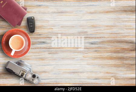 Appareil photo vintage, tasse de café, passeport et clé de voiture sur une table en bois d'affaires ou bureau vue sur le dessus avec espace de copie pour le design et l'utilisation. Banque D'Images