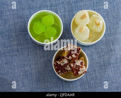 Nariyal, Chocolate, Pista Petta ou Agra Angoori Kesar Petta sont des sucreries indiennes aromatisées, dessert à base de citrouille et servi dans des bols sur fond clair Banque D'Images