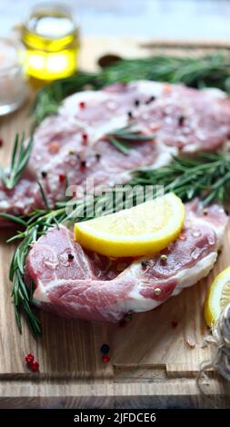 Steaks de porc crus au romarin, au gros sel et au citron. Porc frais. Steak de cou. Céto à la viande biologique Pega. Alimentation Paleo. Banque D'Images