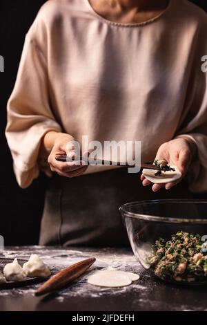 Empaquetage des boulettes, le processus de fabrication des boulettes traditionnelles chinoises - photo de stock Banque D'Images