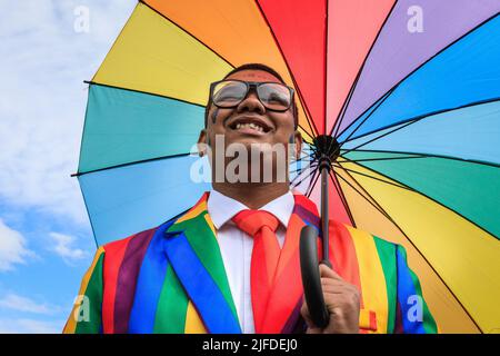 Londres, Royaume-Uni. 02nd juillet 2022. Un participant pose fièrement avec le parapluie de drapeau arc-en-ciel pendant l'accumulation à Park Lane. Les participants et les spectateurs s'amusent le long de la route de la parade de la fierté à Londres 2022. Cette année, la parade progresse de Hype Park le long de Piccadilly jusqu'à Whitehall. Le mouvement Pride et la communauté LGBT commémore 50 ans depuis la première Pride au Royaume-Uni. Credit: Imagetraceur/Alamy Live News Banque D'Images