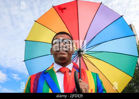 Londres, Royaume-Uni. 02nd juillet 2022. Un participant pose fièrement avec le parapluie de drapeau arc-en-ciel pendant l'accumulation à Park Lane. Les participants et les spectateurs s'amusent le long de la route de la parade de la fierté à Londres 2022. Cette année, la parade progresse de Hype Park le long de Piccadilly jusqu'à Whitehall. Le mouvement Pride et la communauté LGBT commémore 50 ans depuis la première Pride au Royaume-Uni. Credit: Imagetraceur/Alamy Live News Banque D'Images