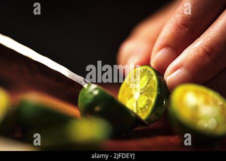 Couper la petite lime en deux, fraîche et fruitée de la boisson froide processus de fabrication - photo de stock Banque D'Images