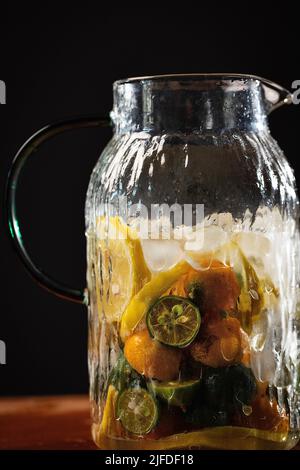 Agrumes réfrigérés dans des pots en verre, frais et fruité boisson froide processus de fabrication - photo de stock Banque D'Images