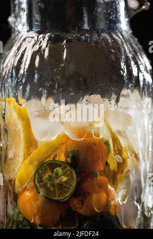 Agrumes réfrigérés dans des pots en verre, frais et fruité boisson froide processus de fabrication - photo de stock Banque D'Images