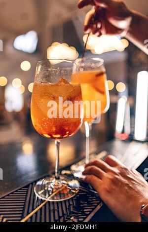 Barman mélangeant le cocktail aperol Spritz sur le comptoir du bar Banque D'Images