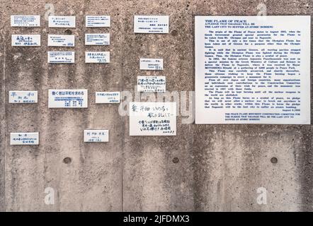 nagasaki, kyushu - décembre 11 2021: Voeux de paix et explications sur plaques céramiques sur un mur sur l'histoire du monument en forme de grec Banque D'Images