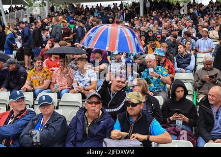 Les fans se mettent sous leurs closes pendant que la pluie s'arrête de jouer pour une deuxième fois Banque D'Images