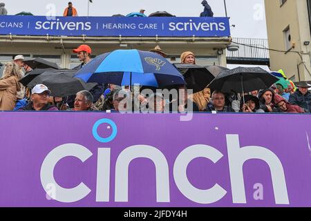 Les fans se mettent sous leurs closes pendant que la pluie s'arrête de jouer pour une deuxième fois Banque D'Images