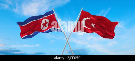 Deux drapeaux croisés la Corée du Nord et la Turquie agitant sous le vent à ciel nuageux. Concept de relation, de dialogue, de voyage entre deux pays. 3d illustrateur Banque D'Images