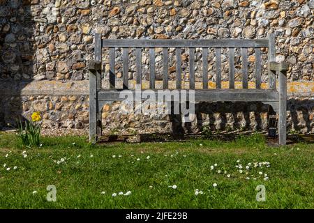 Un banc dans le cimetière de l'église All Saints dans le joli village de Thornham à Norfolk, Royaume-Uni. Banque D'Images