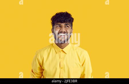 Le gars heureux avec l'expression drôle est de penser à de nouvelles opportunités ou d'imaginer quelque chose de gentil. Banque D'Images