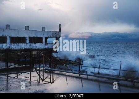 Tempête en mer avec vagues sous la pluie et nuageux au printemps à Alupka. Crimée Banque D'Images