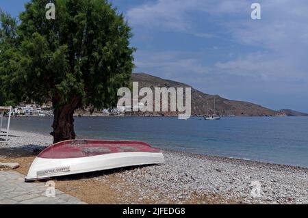 Bateau de pêche retourné sous un arbre tamarisque. Le Marco Polo, scène de plage, village Livadia, île de Tilos, Dodcanese, Grèce Banque D'Images