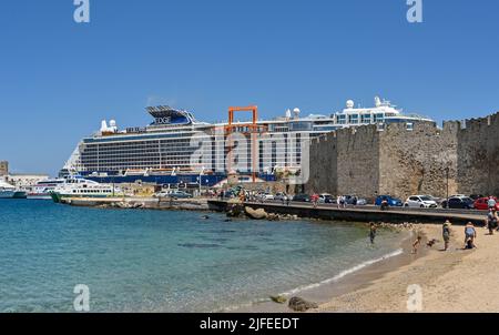 Rhodes, Grèce destination - Mai 2022: Vue panoramique du port avec le bateau de croisière Celebrity Edge à quai. Sur la droite se trouvent les murs de la vieille ville. Banque D'Images