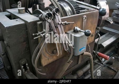 Gros plan d'un équipement spécial de mesure comme des étriers, des diviseurs et une boussole de l'ancienne machine de tournage. Machines industrielles d'époque dans une ancienne usine. Banque D'Images