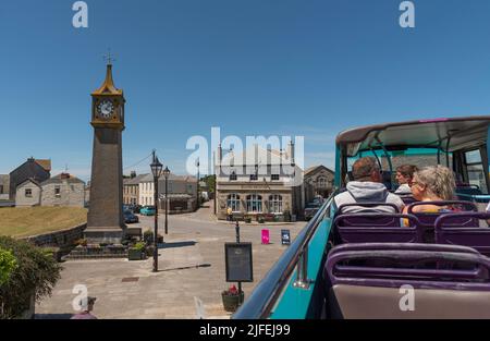 Cornwall, Angleterre, Royaume-Uni. 2022. Passagers voyageant sur un bus touristique à toit ouvert à St juste une petite ville de Cornish. Avec l'horloge du mémorial de la guerre. ROYAUME-UNI Banque D'Images