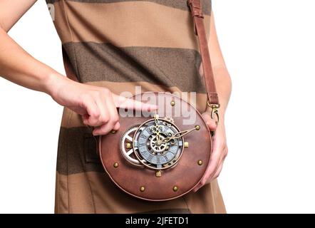 La femelle montre un sac en cuir circulaire avec des rivets et des cogs isolés sur fond blanc. Banque D'Images