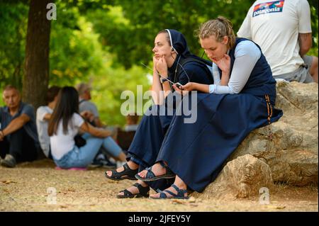 Deux jeunes nonnes, entre autres pèlerins, à l'écoute d'une catéchèse pendant Mladifest 2021 - le festival de la jeunesse - à Medjugorje. Banque D'Images