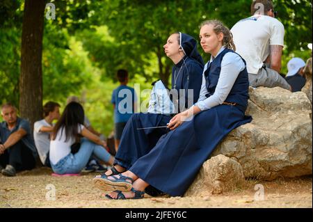 Deux jeunes nonnes, entre autres pèlerins, à l'écoute d'une catéchèse pendant Mladifest 2021 - le festival de la jeunesse - à Medjugorje. Banque D'Images