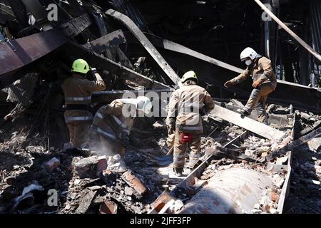 Non exclusif: KREMENCHUK, UKRAINE - 28 JUIN 2022 - les sauveteurs ont dégagé les décombres après que deux missiles russes ont frappé le centre commercial Amstor avec environ 1 000 ci Banque D'Images