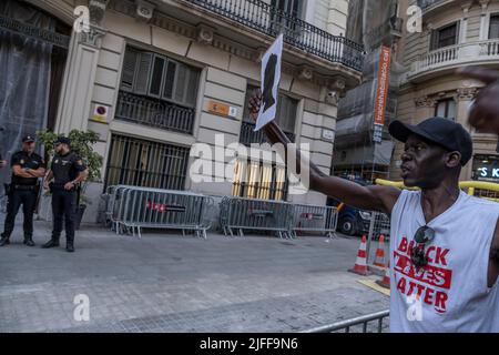 Barcelone, Espagne. 01st juillet 2022. Un manifestant a la silhouette symbolique d'un présumé migrant décédé à Melilla devant les agents de la police nationale au poste de police de Vía Laietana. Des centaines de personnes ont manifesté dans le centre de Barcelone et ont finalement formé un autel sur la place Idrissa Diallo à l'occasion du massacre de Melilla où plus d'une trentaine de migrants africains sont morts en raison de la répression de la police marocaine après avoir essayé de sauter la barrière espagnole. (Photo par Paco Freire/SOPA Images/Sipa USA) crédit: SIPA USA/Alay Live News Banque D'Images