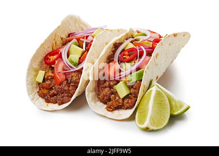 Deux tacos avec bœuf haché et citron vert sur fond blanc Banque D'Images