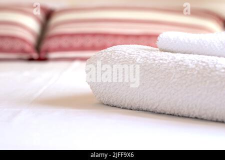 Serviettes blanches joliment pliées dans une chambre de luxe dans un hôtel Banque D'Images