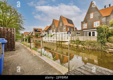 Vue sur les maisons de deux étages vue sur les maisons grises de deux étages, les fenêtres à cadre blanc, les toits carrelés et un canal de bois Banque D'Images