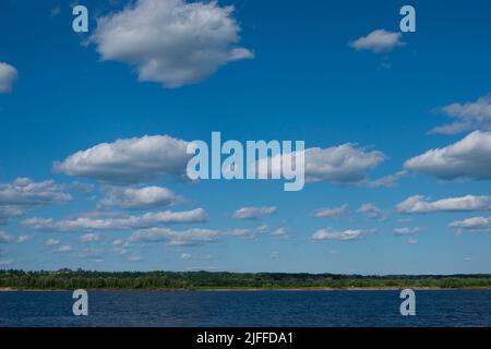 Ryokana de froid profond dans le nord de la Russie. Les saisons sont l'été. Une plage de sable avec des buissons verts qui s'y développent. Nuages blancs dans le ciel bleu Banque D'Images