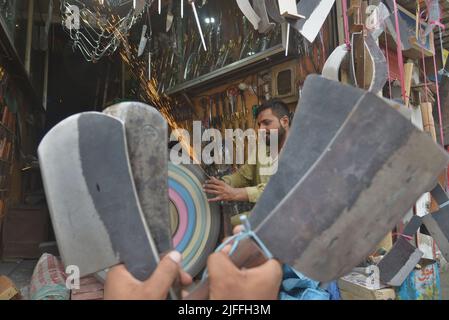 2 juillet 2022, Lahore, Punjab, Pakistan : les forgerons pakistanais aiguisèrent les castors à viande divers outils et couteaux à utiliser pour sacrifier les animaux dans leur magasin de métal avant le festival musulman d'Eid al-Adha à Lahore. EID al-Adha, les musulmans de vacances islamiques les plus importants du monde, célébrera 'Eid ul-Adha', également connu sous le nom de Festival du sacrifice (Qurbani), pour marquer le mois islamique de Zil Hijjah. Abattant des moutons, des chèvres, des vaches et des chameaux pour commémorer la volonté d'Abraham Prophète de sacrifier son fils Ismail sur le commandement de Dieu. (Credit image: © Rana Sajid Hussain/Pacific Press via Banque D'Images