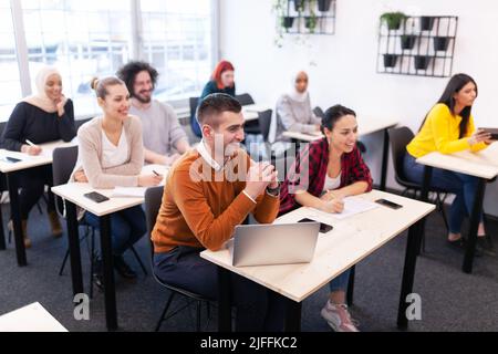Étudiants multiethniques à l'écoute d'un conférencier dans une salle de classe.Des jeunes intelligents étudient à l'université. Banque D'Images