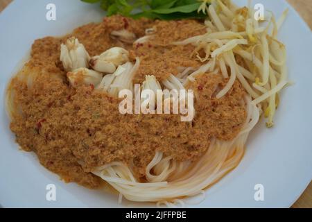 Nouilles de riz à la sauce au curry de crabe ou Khanom Jeen Nam ya Poo en thaï, concentration sélective sur le crabe dans une cuillère. Menu exclusif servi avec des plats frais aux côtés v Banque D'Images