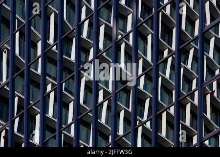 Image abstraite d'une tour de bureau moderne reflétée dans les fenêtres d'un autre immeuble de bureaux à Tokyo, au Japon. Banque D'Images