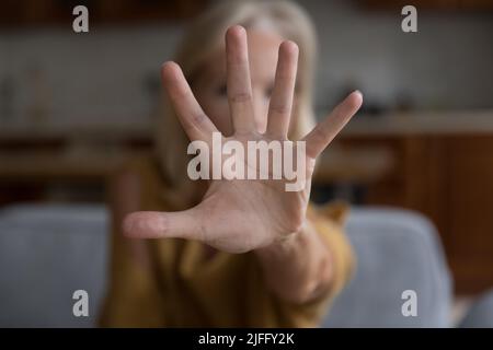 Une femme a tendu sa main à l'appareil photo fait un geste d'arrêt Banque D'Images