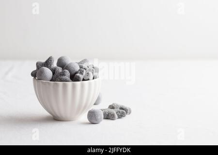 Salmiakki salé à la réglisse en finnois dans un bol blanc avec espace de copie Banque D'Images