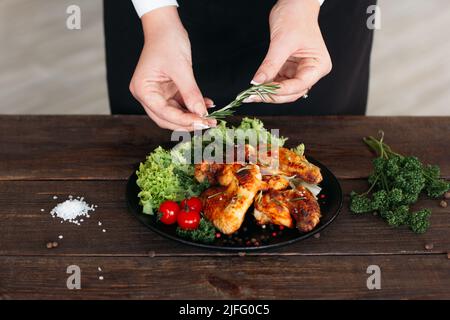 Chef poulet épicé décoré sur une table en bois Banque D'Images