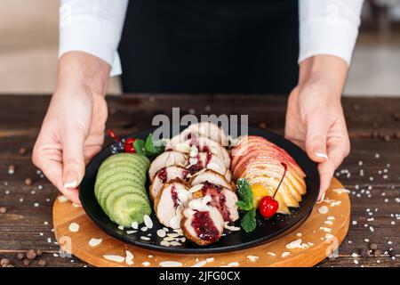 Service de nourriture. Un garçon sert du veau cuit. Banque D'Images