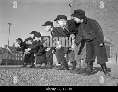 1940s été. Garçons jouant à l'extérieur des billes. Un jeu à l'ancienne où le but est de frapper la pyramide des billes avec juste un marbre. Si vous frappez, vous avez gagné les billes dans la pyramide, sinon le marbre a été perdu. Il y avait aussi des variantes du jeu. Suède avril 1940 Kristoffersson réf. 111-3 Banque D'Images