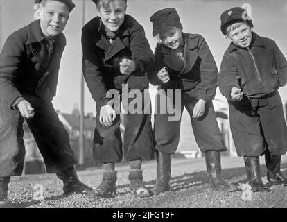 1940s été. Garçons jouant à l'extérieur des billes. Un jeu à l'ancienne où le but est de frapper la pyramide des billes avec juste un marbre. Si vous frappez, vous avez gagné les billes dans la pyramide, sinon le marbre a été perdu. Il y avait aussi des variantes du jeu. Suède avril 1940 Kristoffersson réf. 111-1 Banque D'Images