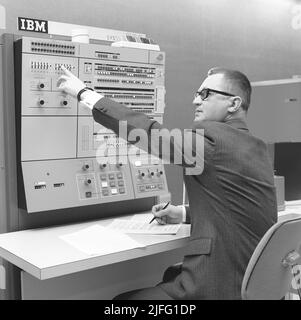 Dans le 1960s. Intérieur d'une salle avec des ordinateurs et des personnes sur le travail des manipuler et d'enregistrer et de lire l'information. Un panneau au-dessus de l'ordinateur central indique IBM 360. IBM System 360 a souvent été vu dans la série télévisée américaine Mad Men. Photo prise 1965 Kristoffersson ref DY125-1 Banque D'Images