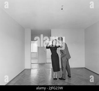 Dans le 1950s. Un jeune couple photographié dans leur nouvel appartement. Elle a l'air créative et positive avec des idées comment décorer. Son langage corporel suggère qu'il est plus réservé et pas aussi spontané. Suède 1957. Banque D'Images