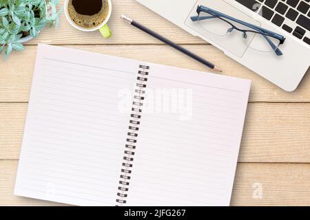 Bureau table avec carnet vierge, ordinateur portable, crayon noir, verres et tasse de café. Vue de dessus avec espace de copie (mise au point sélective). Affaires a Banque D'Images
